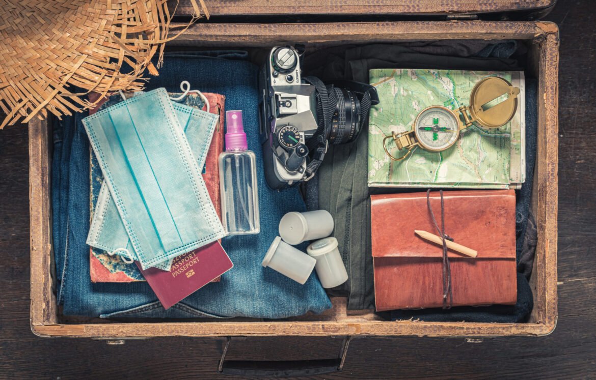 Luggage full of traveler stuff and mask as limitation in traveling. Epidemic limitation. Trip preparation.