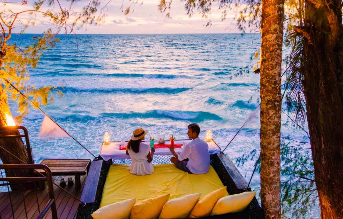 Romantic dinner on the beach in Koh Kood Thailand, a couple of men and woman having dinner on the beach high in the tree at a bird nest in Thailand during sunset