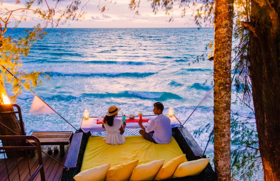Romantic dinner on the beach in Koh Kood Thailand, a couple of men and woman having dinner on the beach high in the tree at a bird nest in Thailand during sunset