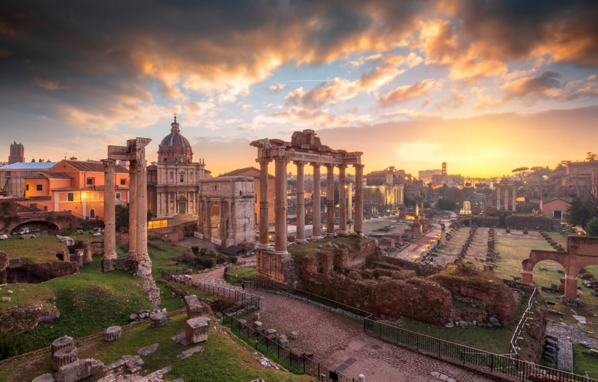 Rome, Italy at the historic Roman Forum ruins at dusk.