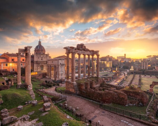 Rome, Italy at the historic Roman Forum ruins at dusk.