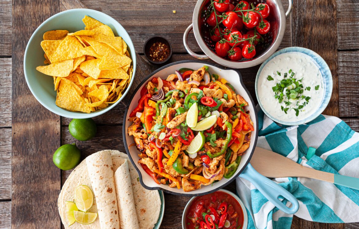 Chicken fajita in a rustic pan with homemade dips