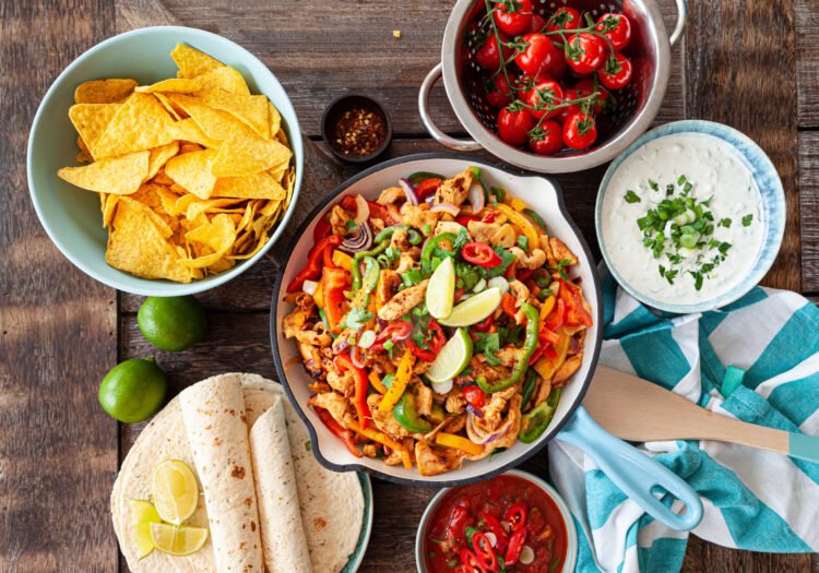 Mexican Food Chicken fajita in a rustic pan with homemade dips