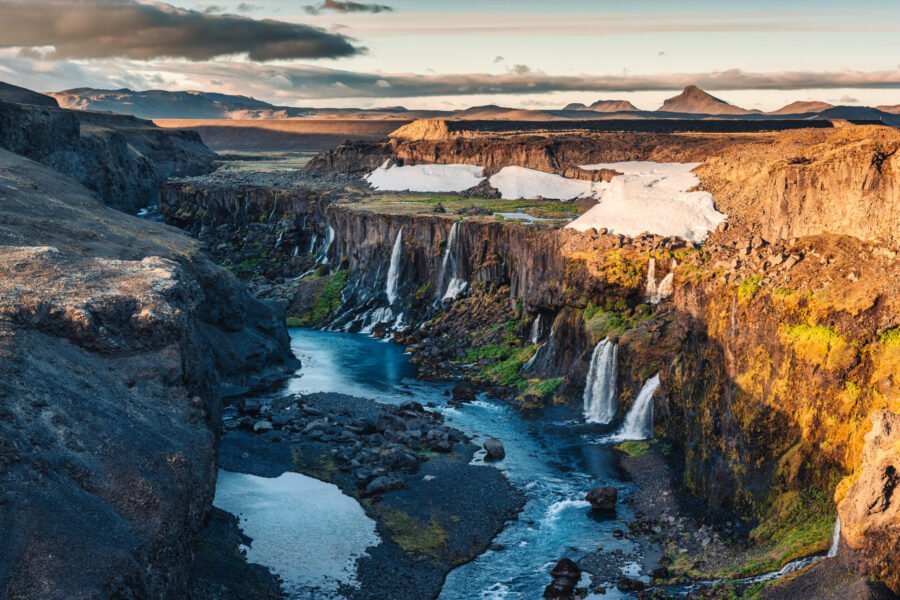 Beautiful sunset over Sigoldugljufur with tiny waterfall flowing in canyon on Icelandic Highlands in summer at Iceland