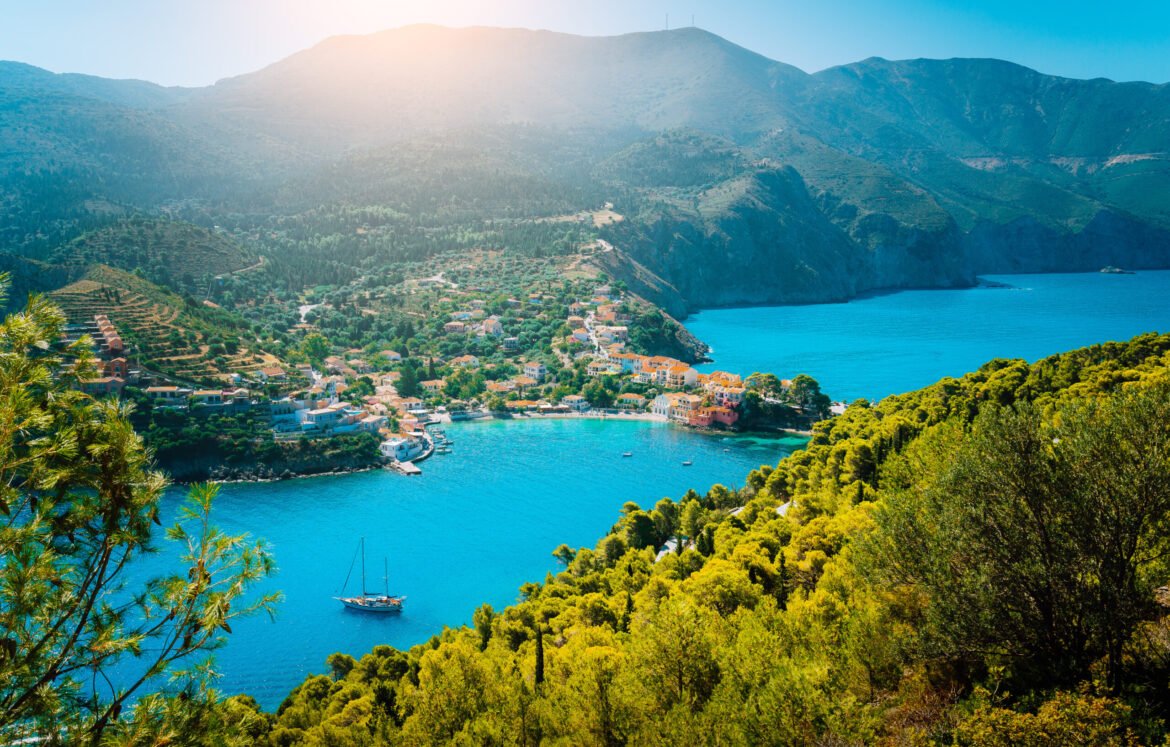 Top view to Assos village Kefalonia. Greece. Beautiful turquoise colored bay lagoon water surrounded by pine and cypress trees along the coastline.