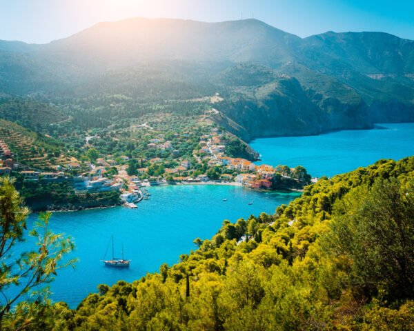 Top view to Assos village Kefalonia. Greece. Beautiful turquoise colored bay lagoon water surrounded by pine and cypress trees along the coastline.