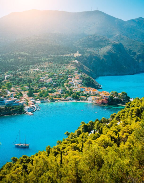 Top view to Assos village Kefalonia. Greece. Beautiful turquoise colored bay lagoon water surrounded by pine and cypress trees along the coastline.