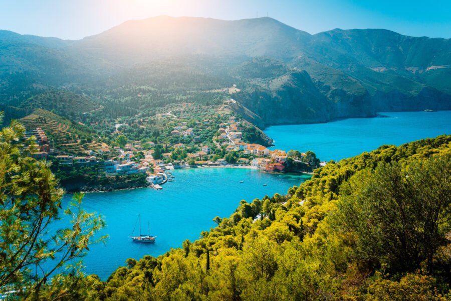 Top view to Assos village Kefalonia. Greece. Beautiful turquoise colored bay lagoon water surrounded by pine and cypress trees along the coastline.