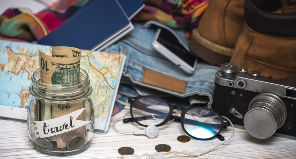 wanderlust. adventure concept. background - what to take for a trip - camera, smartphone, jar with money, glasses, shoes, jeans, accessories