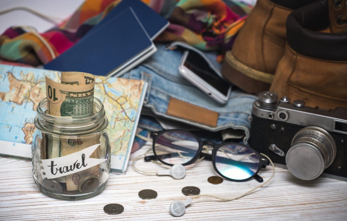 wanderlust. adventure concept. background - what to take for a trip - camera, smartphone, jar with money, glasses, shoes, jeans, accessories