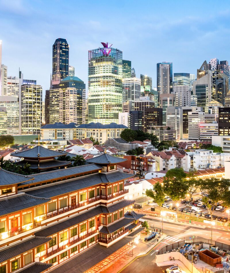 High view of Singapore skyline with skyscrapers and Tooth Relic Temple at blue hour - World famous top south east Asia destinations - City panorama on vivid warm filter with nightscape color tones
